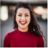 A woman in red shirt smiling for the camera.